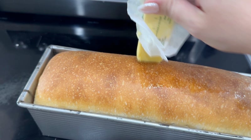 buttering the baked loaf