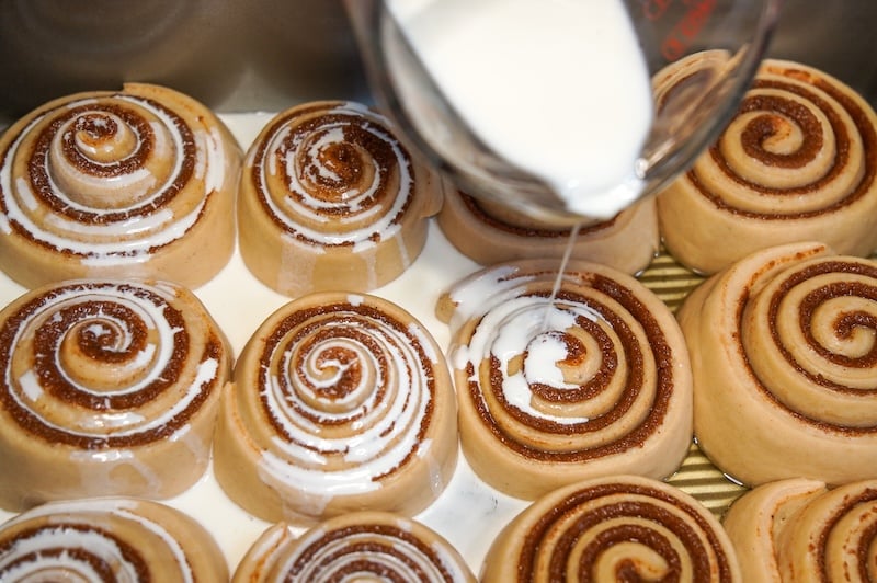 pouring cream on cinnamon rolls