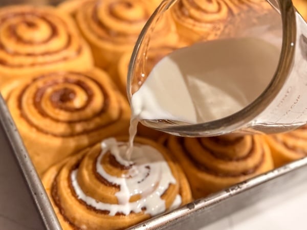 pouring cream on cinnamon rolls
