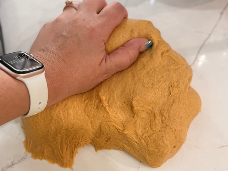kneading the pumpkin cinnamon roll dough