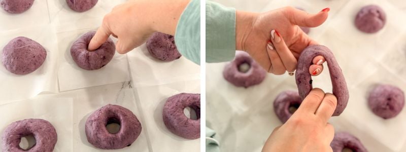 Poking a hole in each dough ball and stretching it open with index and middle fingers to shape the bagels