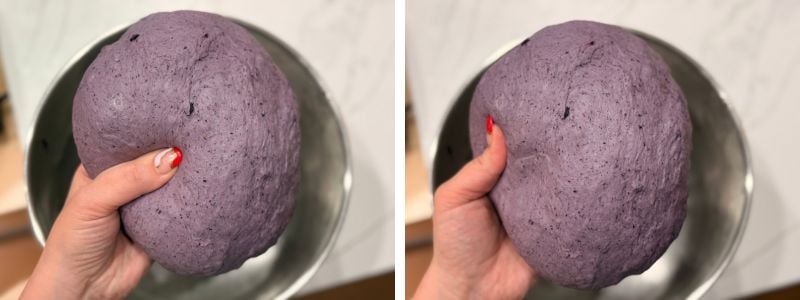 purple blueberry sourdough bagel dough held in a hand, showing the stiff, smooth texture similar to playdough