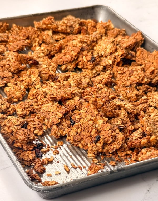 Crunchy Oats and Honey Sourdough Discard Granola with raisins in sheet pan