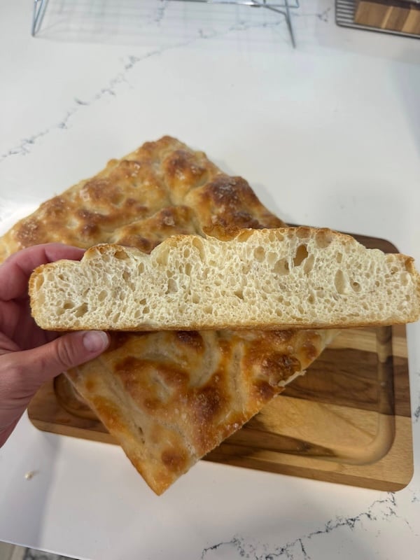 hand of a Recipe Tester holding a cross-section slice of focaccia