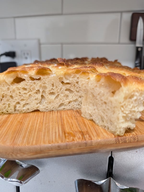 Recipe Tester loaf on a wooden board, showing an airy crumb 