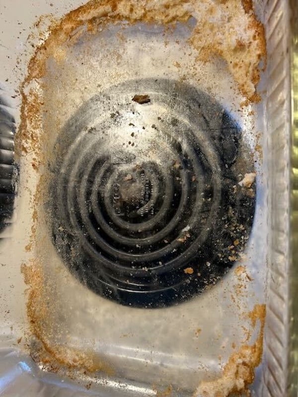 empty glass baking dish with browned residue and stuck focaccia crumbs left on the bottom