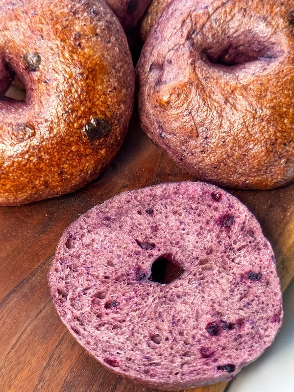 wild blueberry sourdough bagels showing the deep purple interior crumb and shiny crust