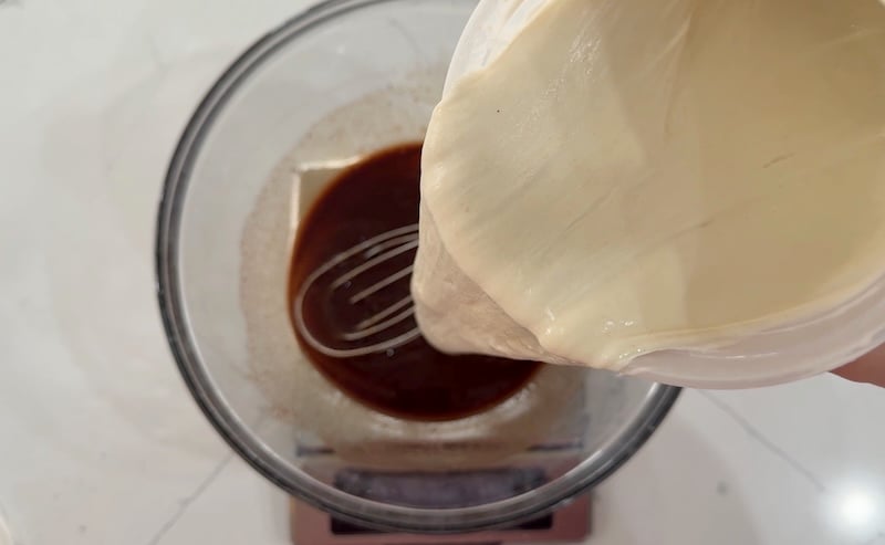 sourdough starter being poured into wet ingredients
