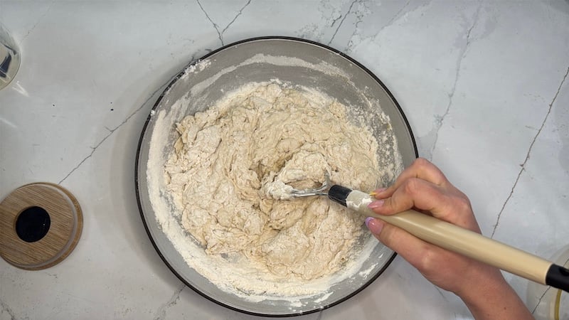 mixing flour into the liquids using a Danish dough whisk 