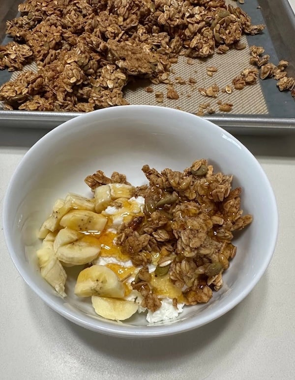 granola with bananas and honey in yogurt bowl