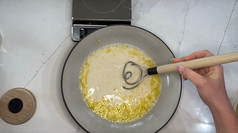 mixing focaccia recipe liquids together in a large bowl