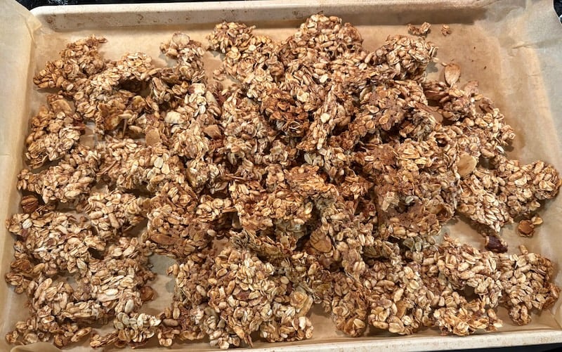 large clusters of baked granola on sheet pan
