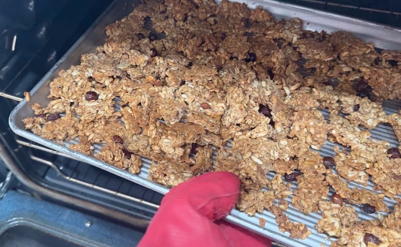 pulling sheet pan with finished granola out of the oven