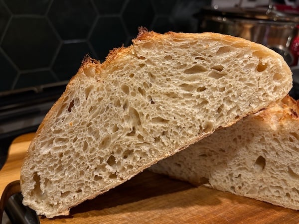 50% einkorn sourdough boule sliced in half, showing an open crumb