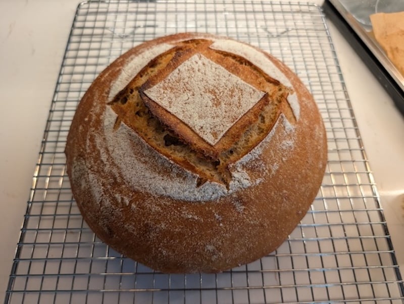 50% einkorn sourdough boule with a square score pattern, on a cooling rack
