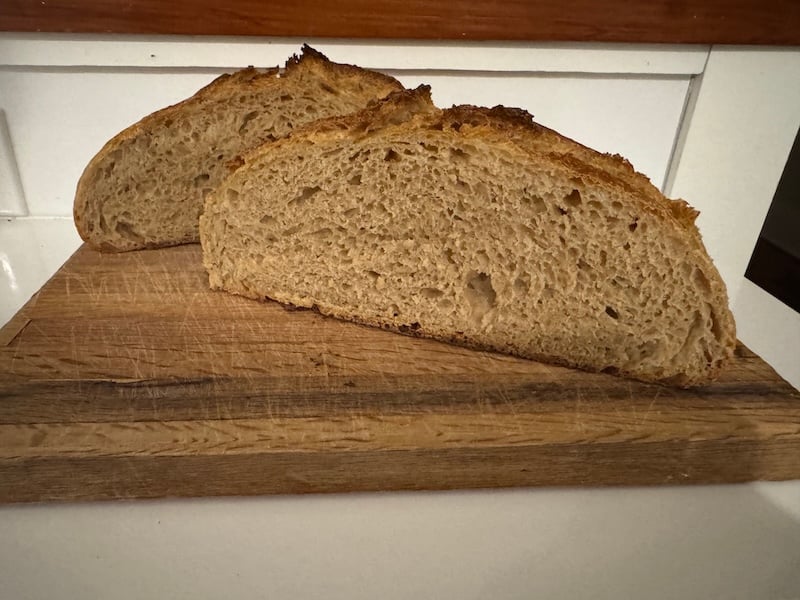 50% einkorn sourdough boule sliced in half, showing the crumb, on a cutting board