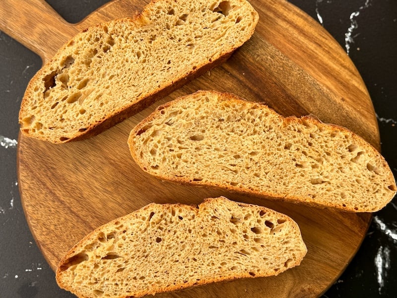 Three slices of einkorn sourdough bread showing the open crumb