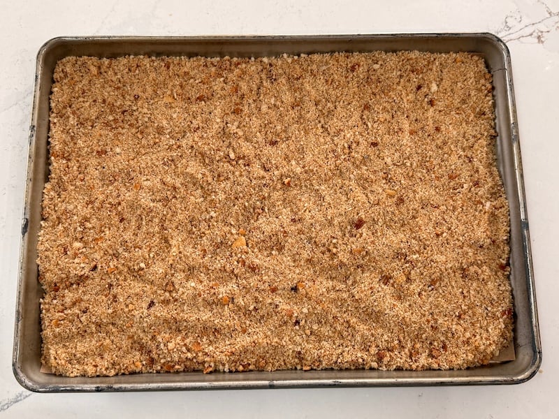 seasoned sourdough breadcrumbs spread evenly on a parchment-lined half sheet pan before baking