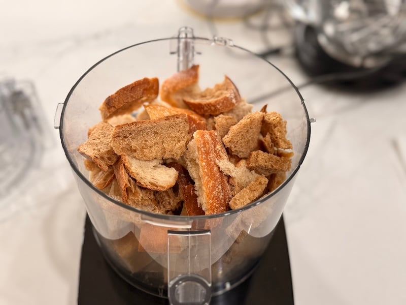 stale sourdough bread pieces in a food processor ready to be turned into breadcrumbs