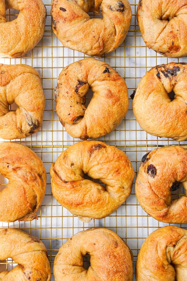 12 cinnamon raisin swirl bagels on a cooling rack