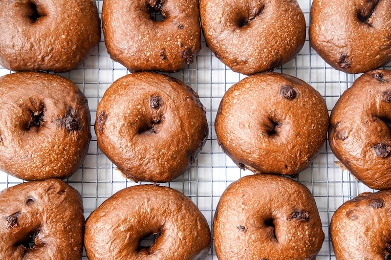 overhead view of chocolate chip bagels cooling on a wire rack