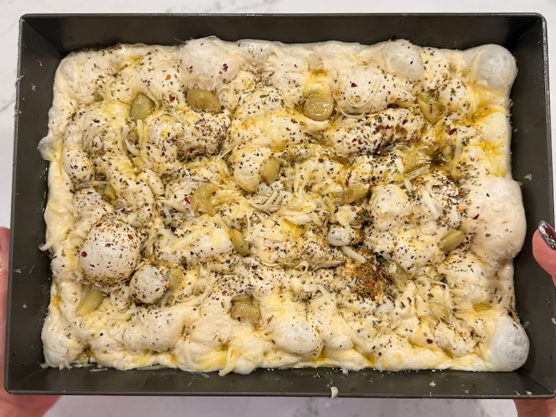 bubbly focaccia dough after dimpling the surface with your fingers