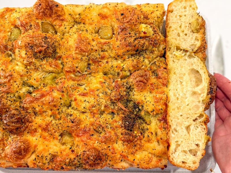 overhead view of garlic cheese focaccia with browned top and open crumb