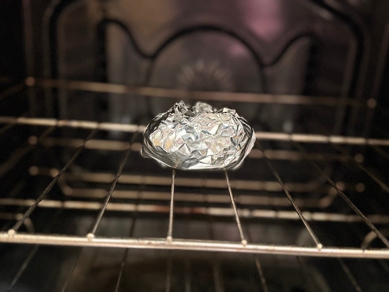 foil-wrapped garlic roasting on an oven rack