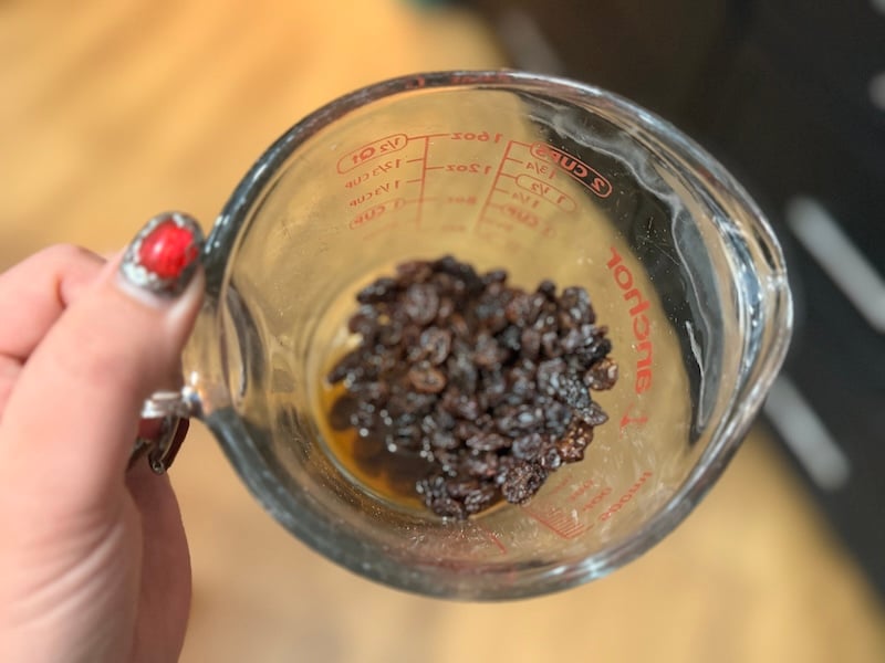 raisins soaking in a mixture of vanilla and water