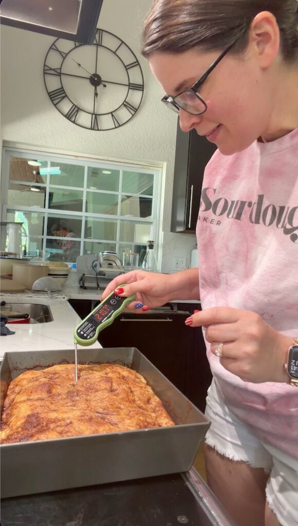 checking internal temp of cinnamon roll focaccia dough