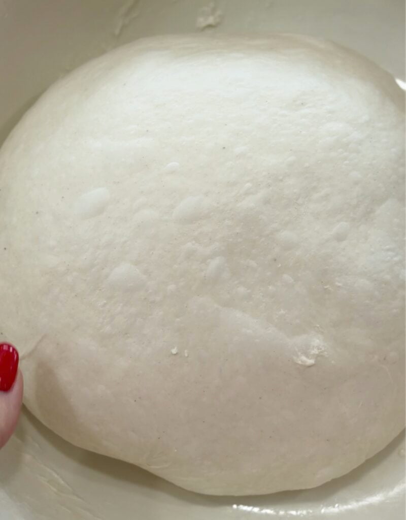focaccia dough after the third round of coil folds, smooth, puffy, and more elastic