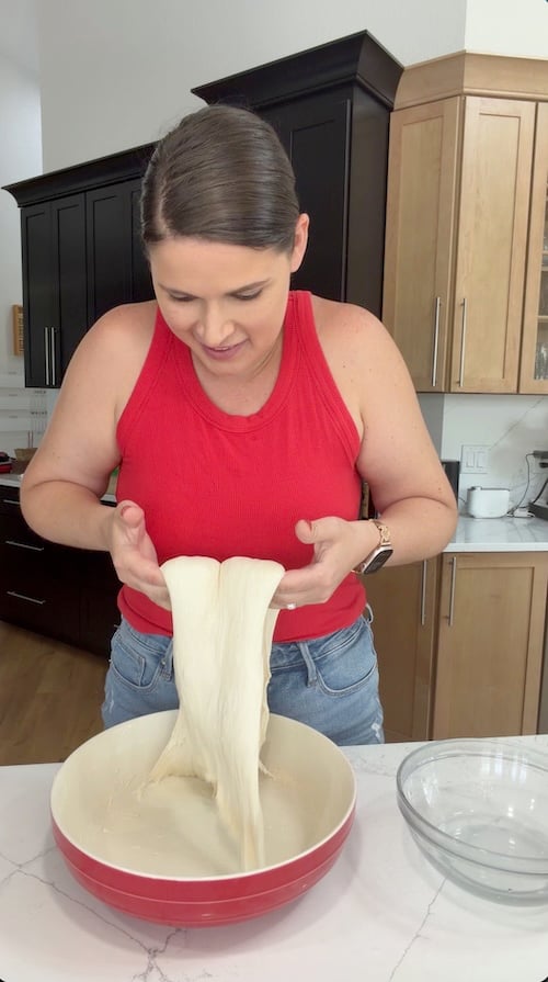 lifting and stretching focaccia dough during a coil fold