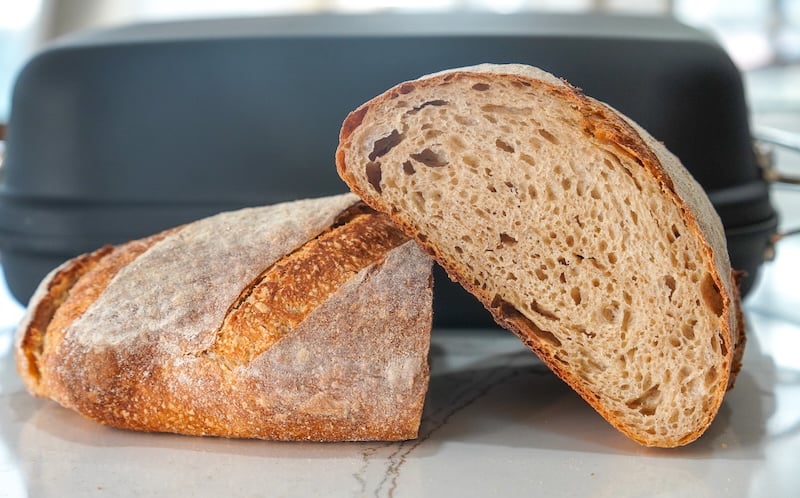 hint of rye sourdough bread sliced in half in front of a bread oven