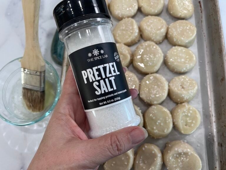putting pretzel salt on boiled and buttered pretzel bites