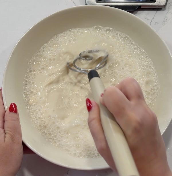 whisking water, sugar, and starter together