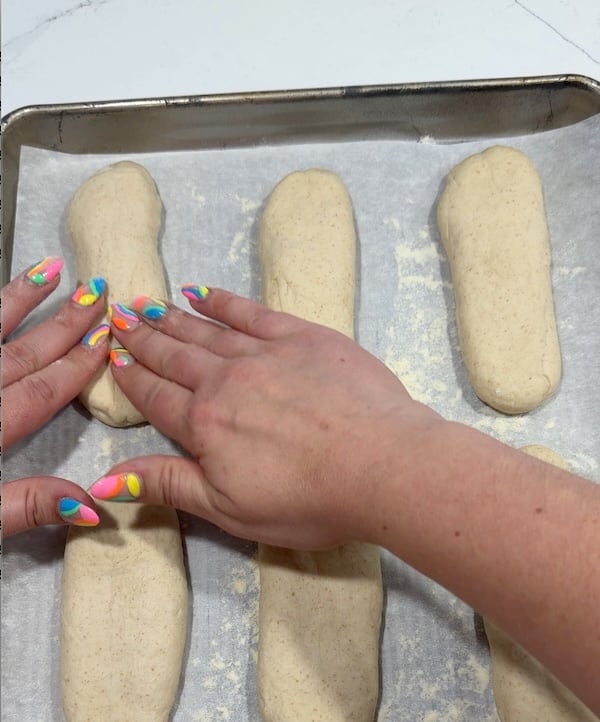pressing down hoagie rolls to widen them