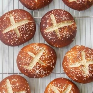 soft sourdough pretzel buns on a cooling rack