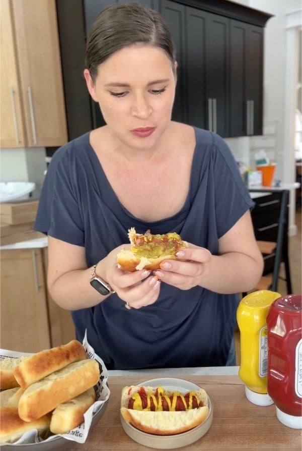 Rebekah eating a hot dog in a sourdough hot dog bun